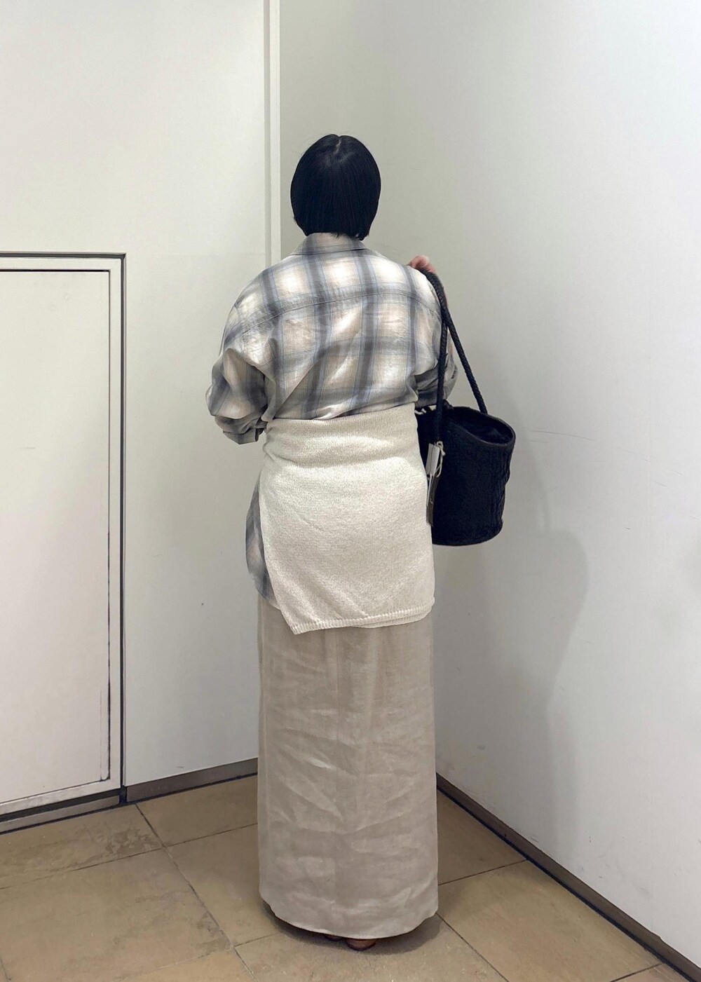 ブラック系のトートバッグ、ベージュ系のスカート、グリーン系のシャツ/ブラウスを着用したレディースの春コーディネートの5枚目の写真