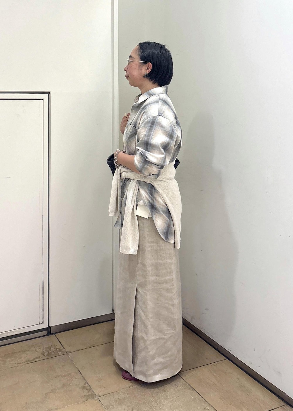 ブラック系のトートバッグ、ベージュ系のスカート、グリーン系のシャツ/ブラウスを着用したレディースの春コーディネートの3枚目の写真