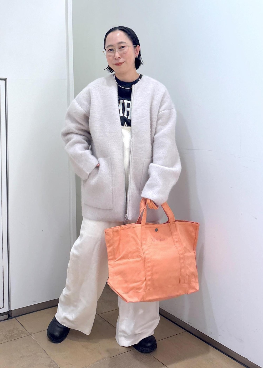 ブラック系のスウェット、グレー系のブルゾン、ホワイト系のサロペット/オーバーオールを着用したレディースの冬コーディネートの2枚目の写真