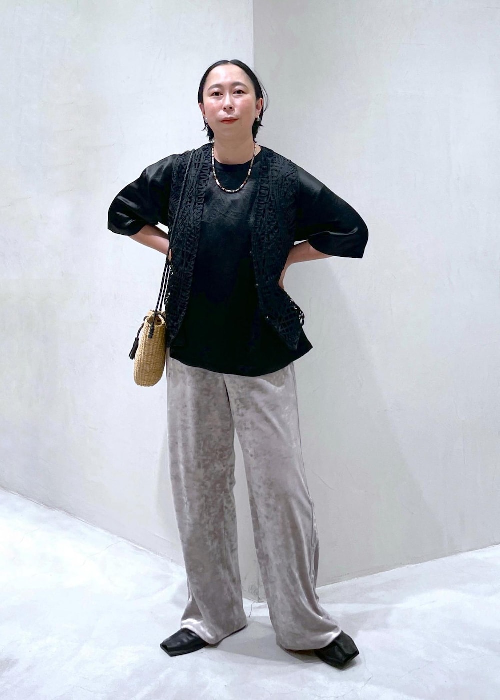 ベージュ系のかごバッグ、ブラック系のベスト、ベージュ系のその他パンツを着用したレディースの夏コーディネートの5枚目の写真