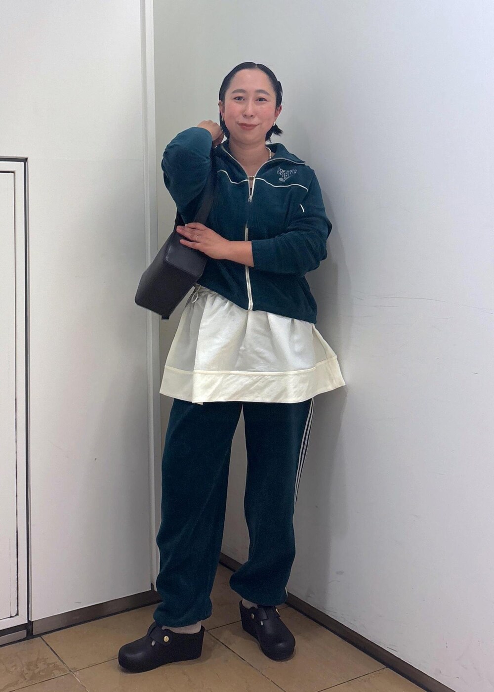 ブラック系のショルダーバッグ、ブラック系のタンクトップ、グリーン系のその他パンツを着用したレディースの冬コーディネートの2枚目の写真