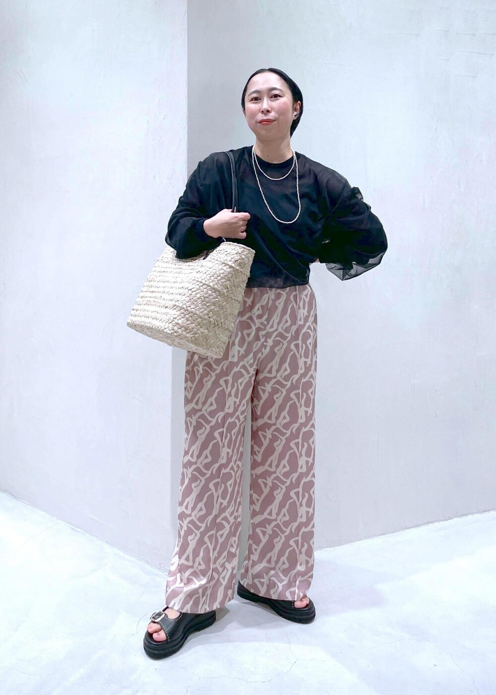 イエロー系のその他パンツ、ブラック系のサンダル、ブラック系のTシャツ/カットソーを着用したレディースの春コーディネートの2枚目の写真