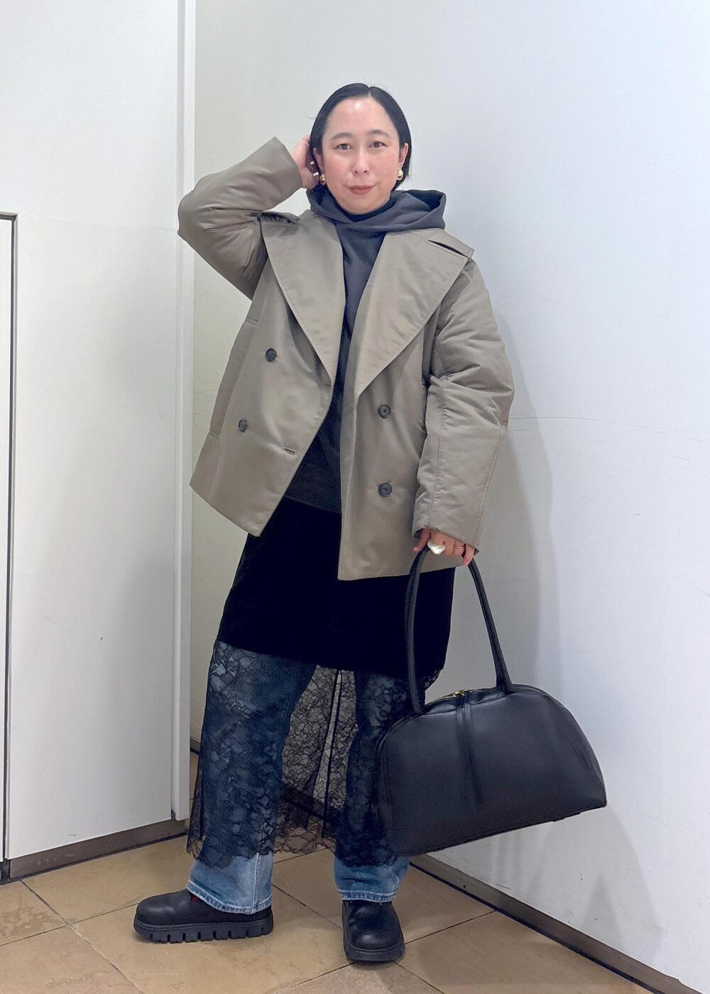 グレー系のパーカー、グリーン系のダウンジャケット/コート、ブラック系のボストンバッグを着用したレディースの冬コーディネートの4枚目の写真