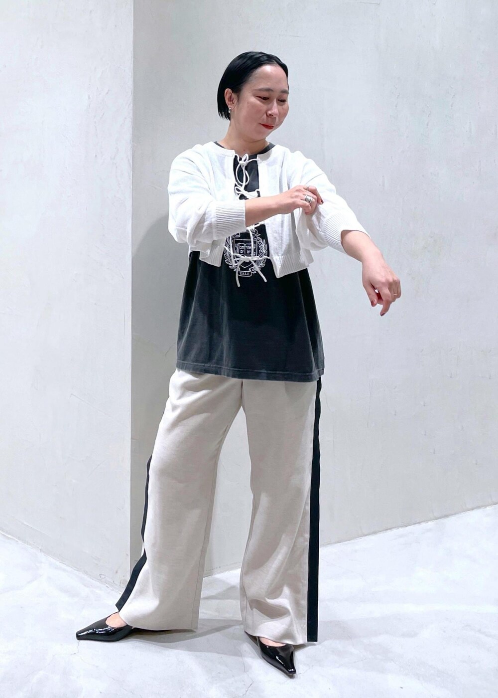 ブラック系のその他シューズ、ブラック系のTシャツ/カットソー、ホワイト系のニット/セーターを着用したレディースの春コーディネートの4枚目の写真