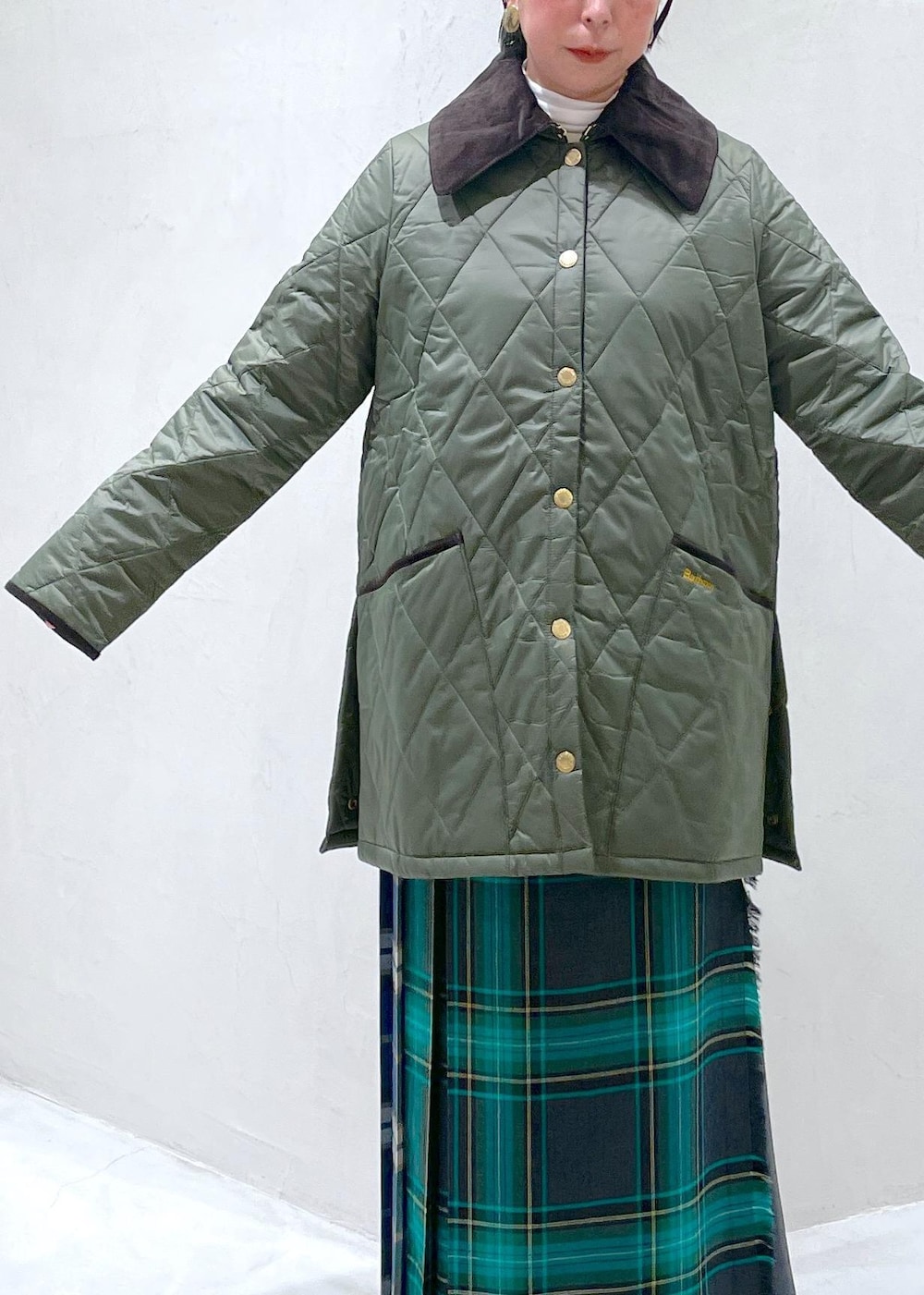 ブラック系のハンドバッグ、グリーン系のスカート、ホワイト系のTシャツ/カットソーを着用したレディースの秋コーディネートの4枚目の写真