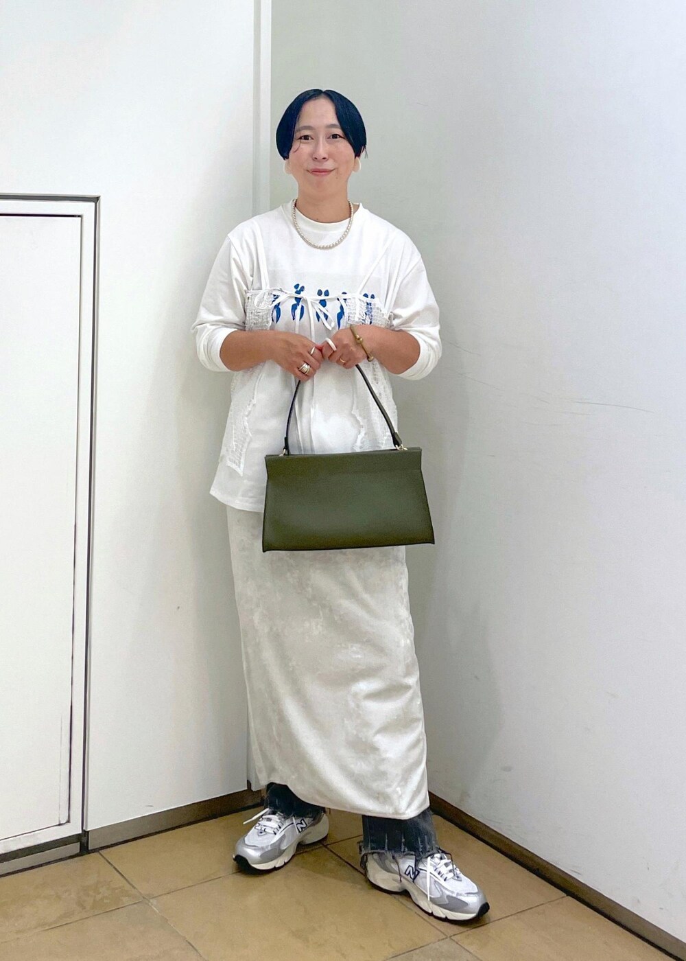 ホワイト系のスカート、ブラック系のデニムパンツを着用したレディースの夏コーディネートの2枚目の写真