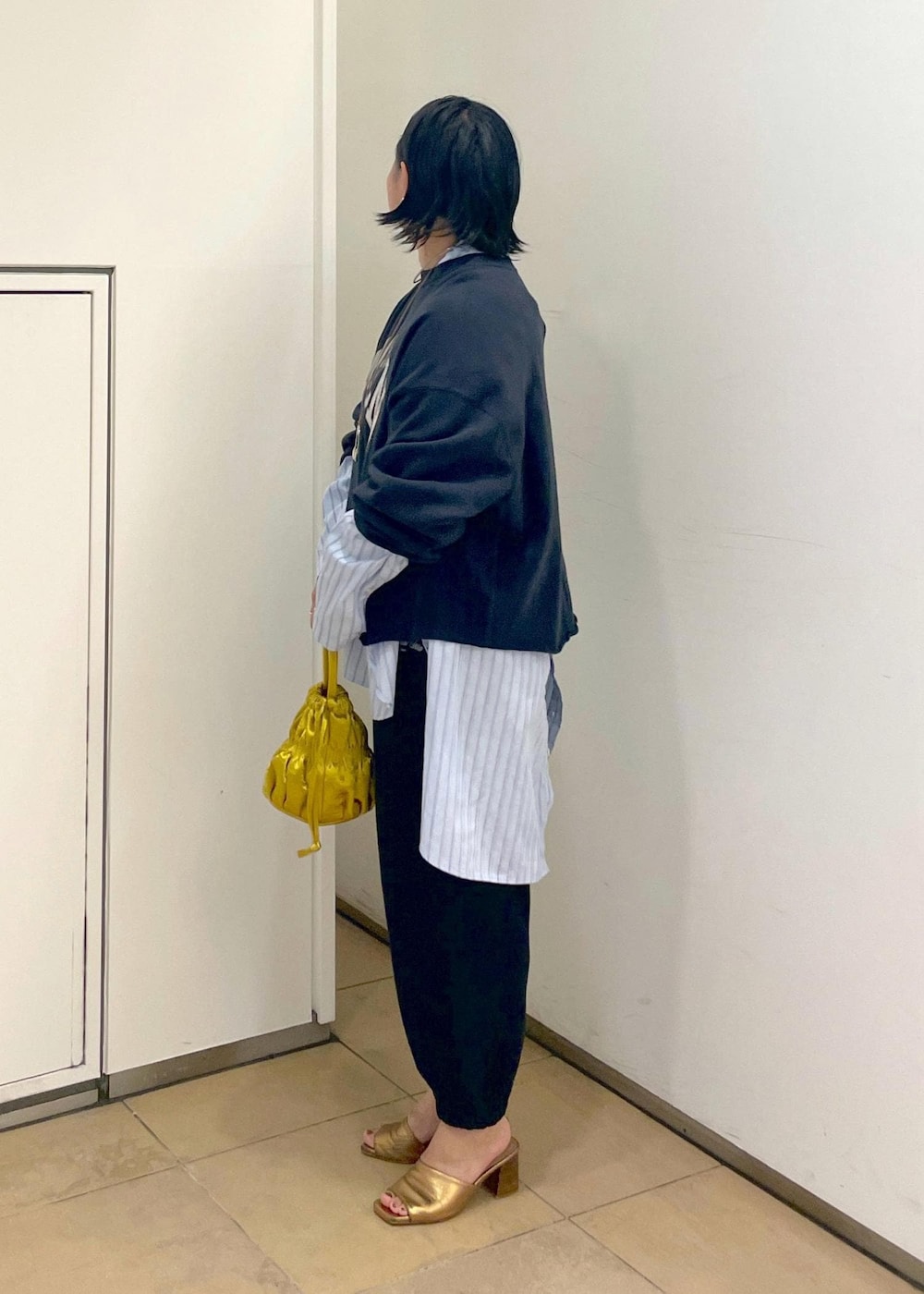 イエロー系のショルダーバッグ、ブラック系のスウェット、ブラック系のスウェットパンツを着用したレディースの夏コーディネートの6枚目の写真