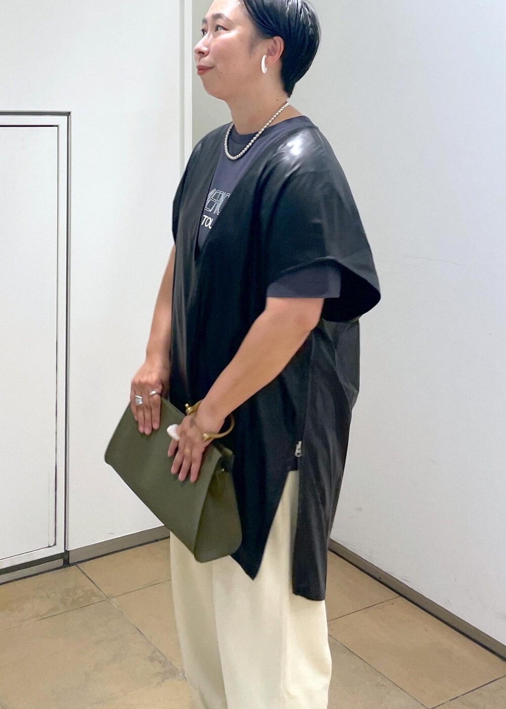 グリーン系のショルダーバッグ、ブラック系のTシャツ/カットソー、ホワイト系のスウェットパンツを着用したレディースの夏コーディネートの9枚目の写真