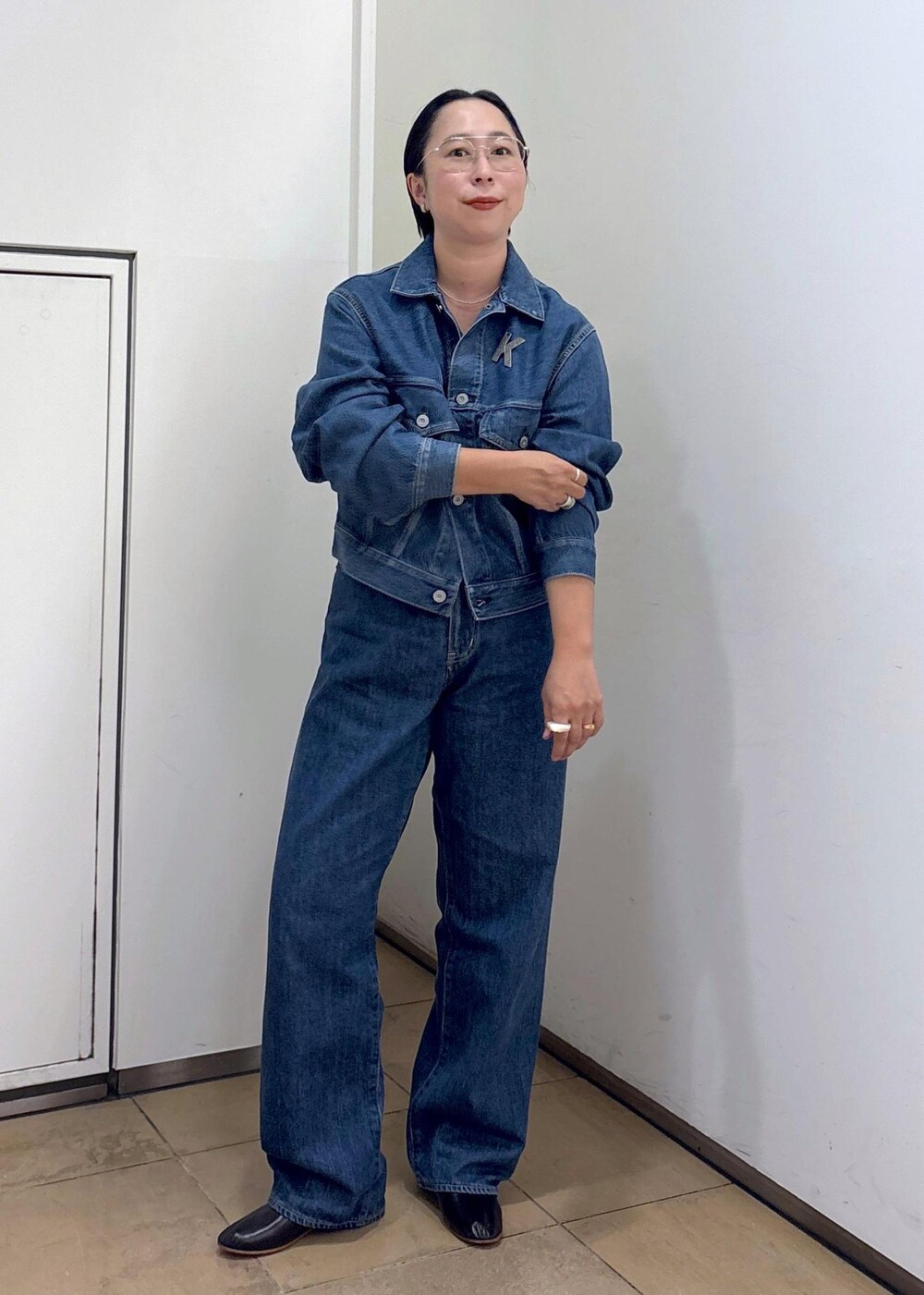 ブルー系のデニムジャケット、ブルー系のデニムパンツ、ブラック系のパンプスを着用したレディースの秋コーディネートの3枚目の写真