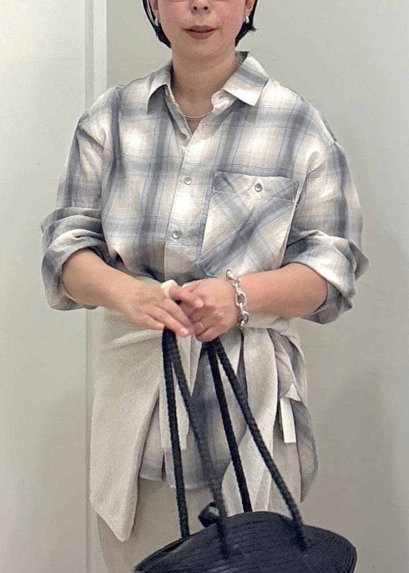 ブラック系のトートバッグ、ベージュ系のスカート、グリーン系のシャツ/ブラウスを着用したレディースの春コーディネートの6枚目の写真