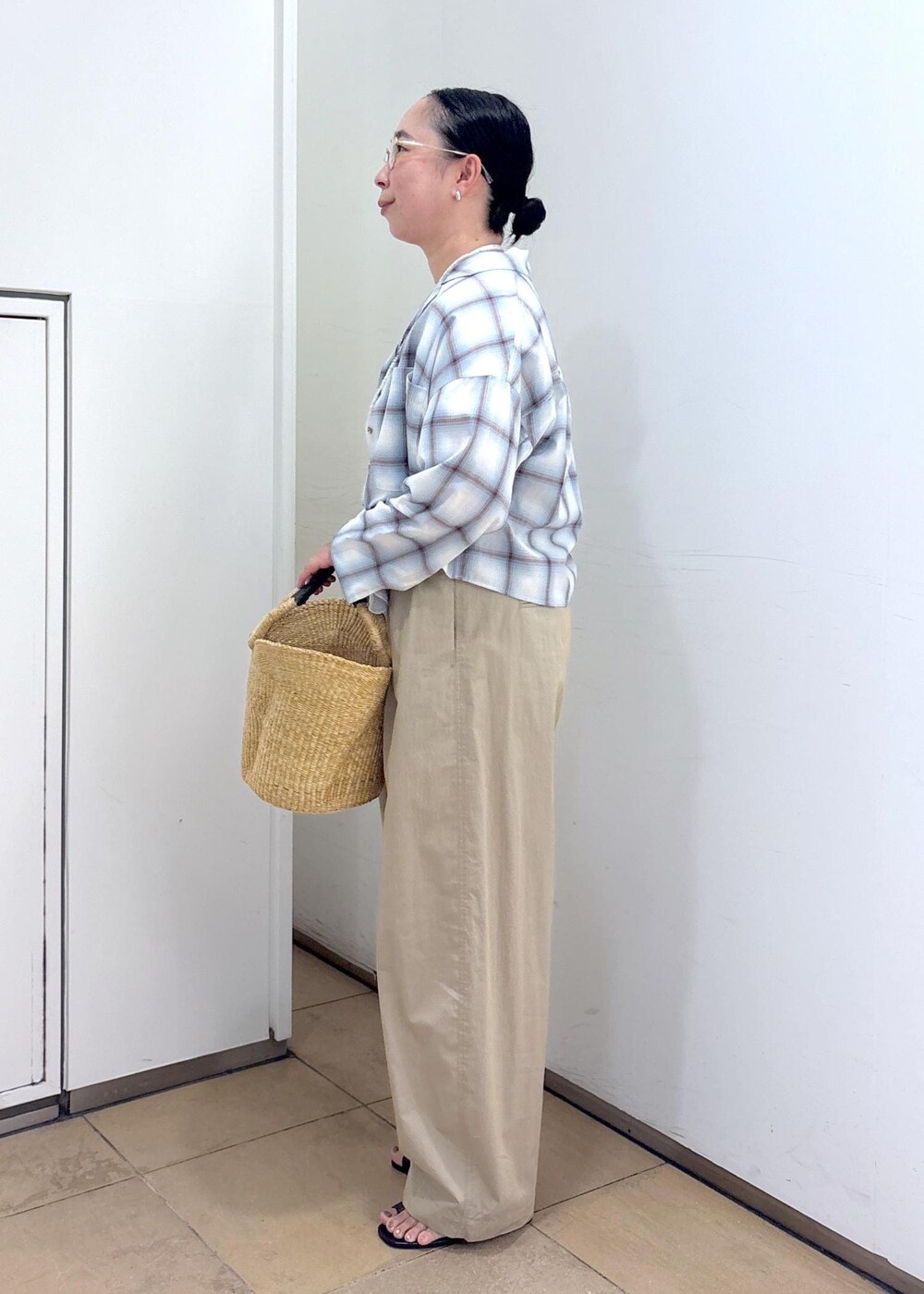 ホワイト系のトートバッグ、ブラック系のサンダル、グレー系のタンクトップを着用したレディースの夏コーディネートの7枚目の写真