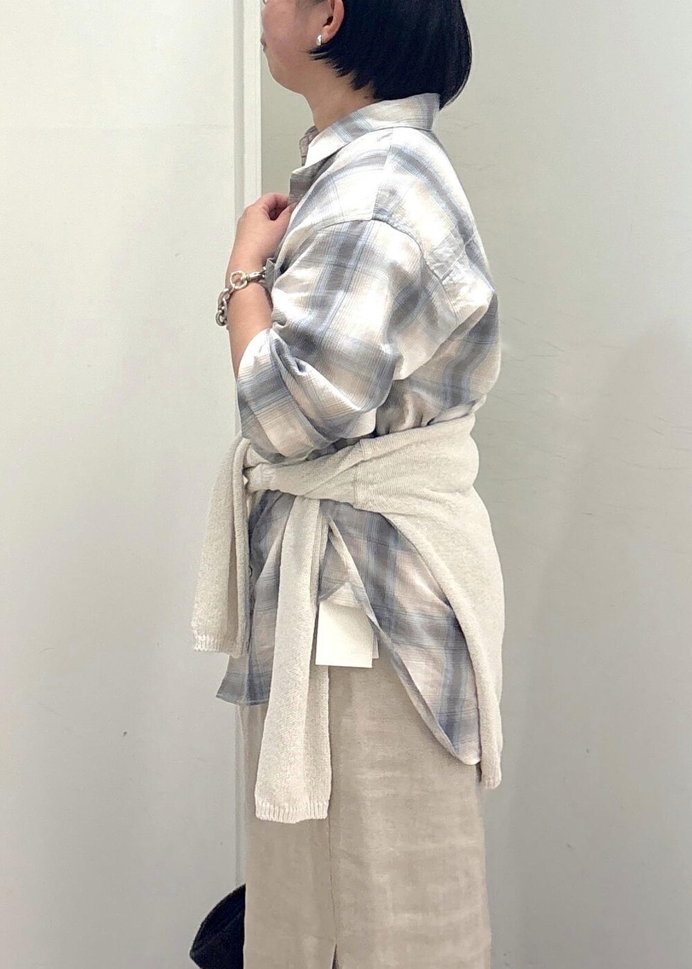 ブラック系のトートバッグ、ベージュ系のスカート、グリーン系のシャツ/ブラウスを着用したレディースの春コーディネートの7枚目の写真