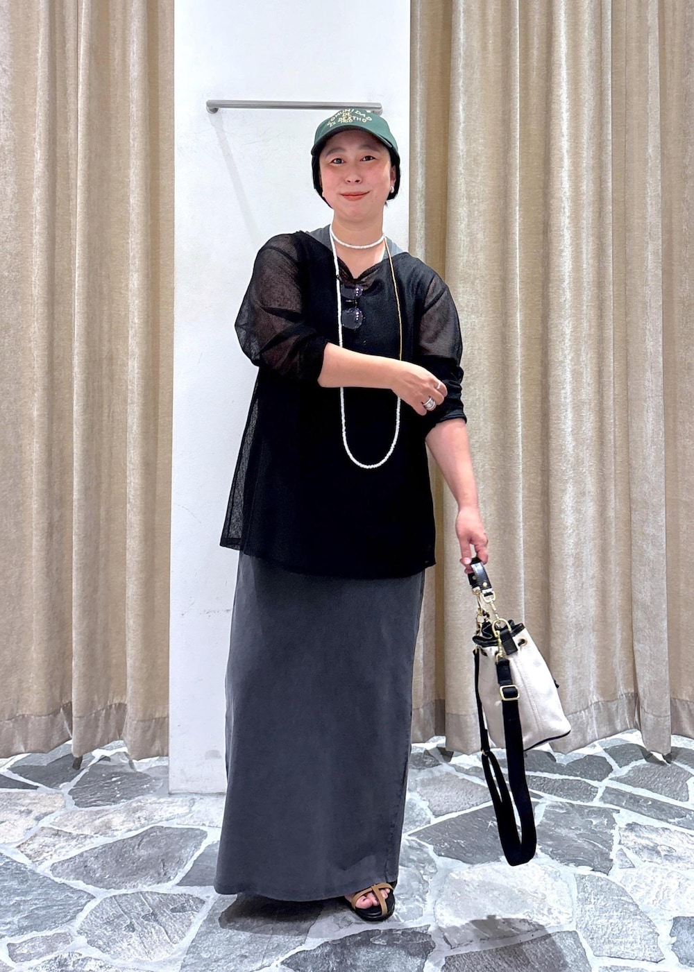 ベージュ系のサンダル、グレー系のワンピース、ブラック系のニット/セーターを着用したレディースの夏コーディネートの2枚目の写真