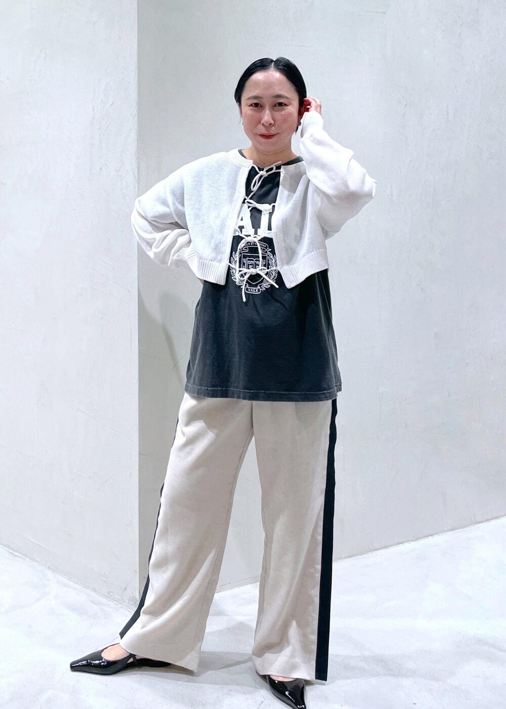 ブラック系のその他シューズ、ブラック系のTシャツ/カットソー、ホワイト系のニット/セーターを着用したレディースの春コーディネートの2枚目の写真