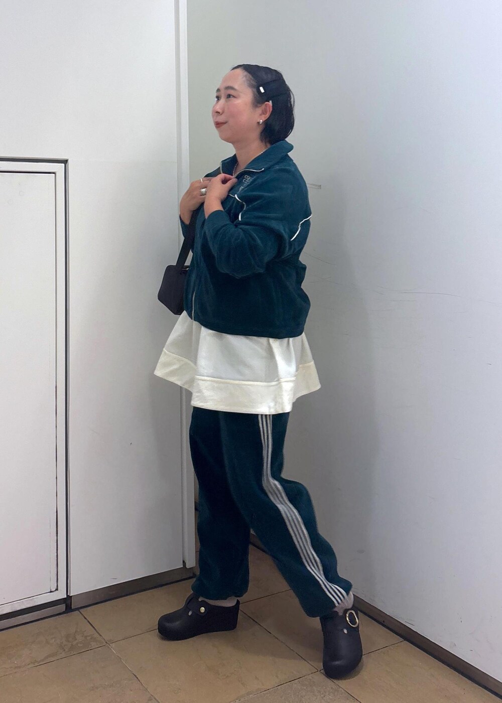 ブラック系のショルダーバッグ、ブラック系のタンクトップ、グリーン系のその他パンツを着用したレディースの冬コーディネートの5枚目の写真