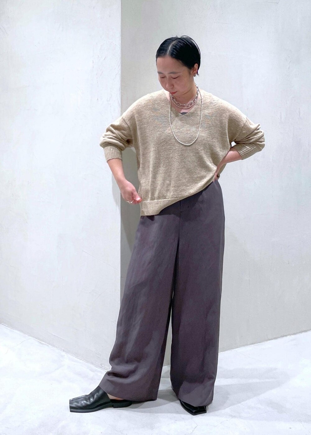 グレー系のつなぎ/オールインワン、ベージュ系のニット/セーターを着用したレディースの春コーディネートの2枚目の写真