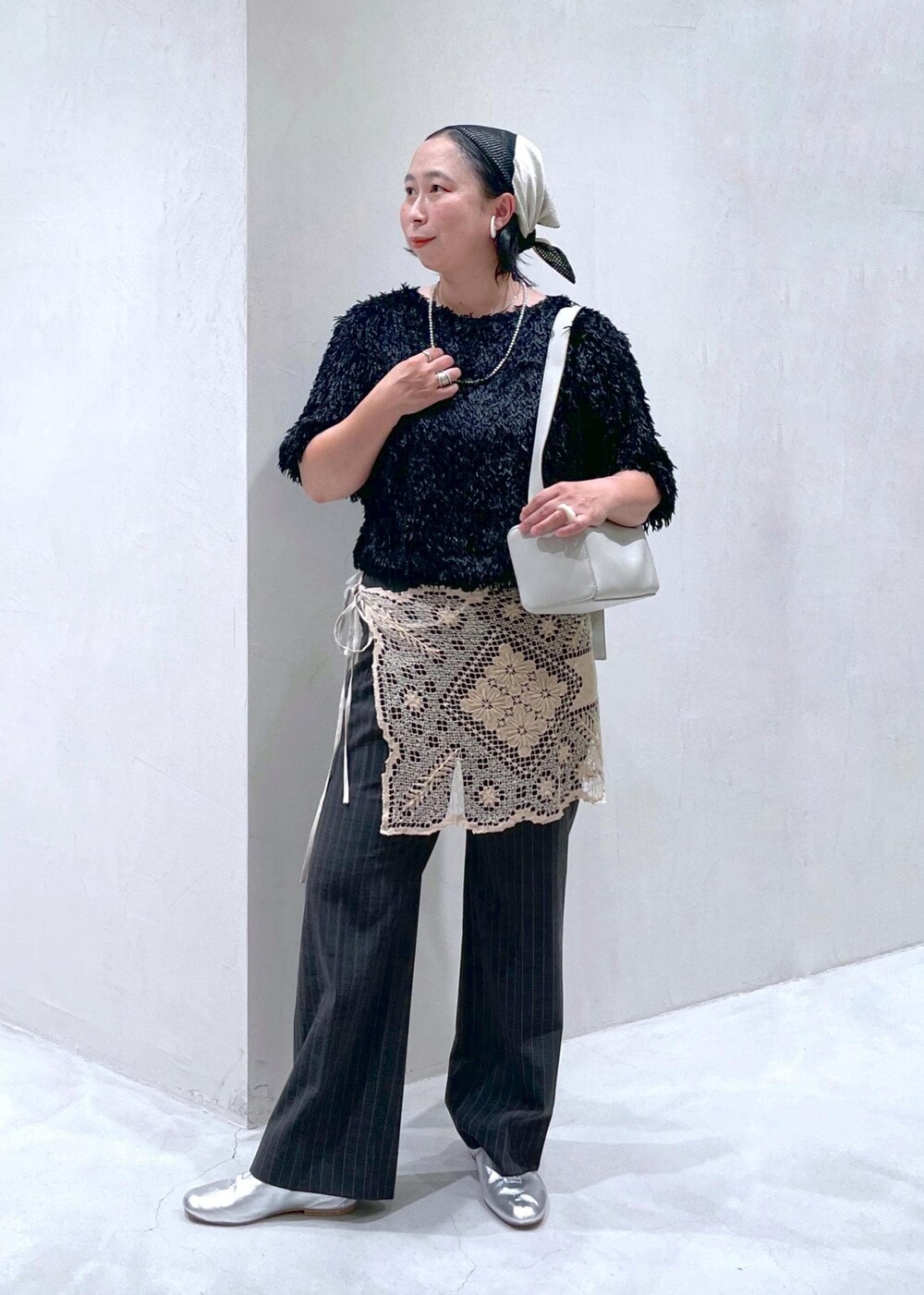 ブラック系のTシャツ/カットソー、グレー系のスラックス、グレー系のショルダーバッグを着用したレディースの夏コーディネートの2枚目の写真