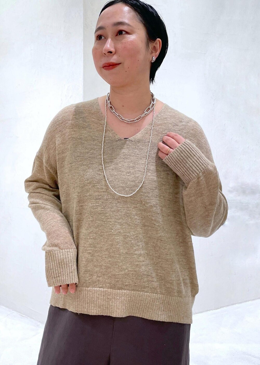 グレー系のつなぎ/オールインワン、ベージュ系のニット/セーターを着用したレディースの春コーディネートの5枚目の写真