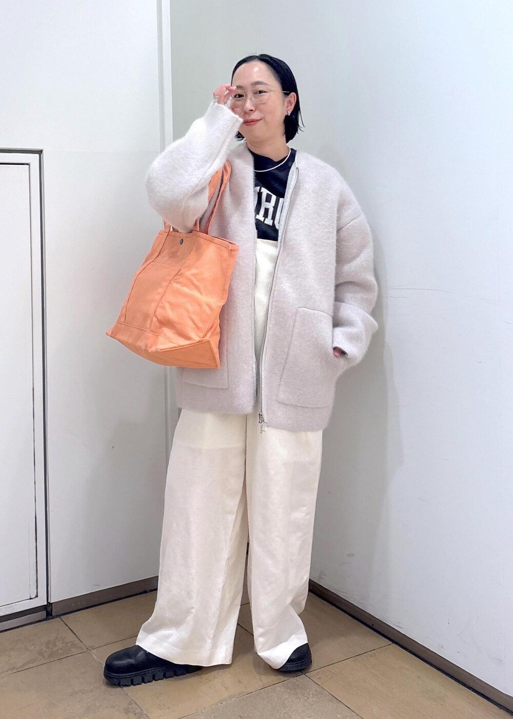 ブラック系のスウェット、グレー系のブルゾン、ホワイト系のサロペット/オーバーオールを着用したレディースの冬コーディネートの4枚目の写真