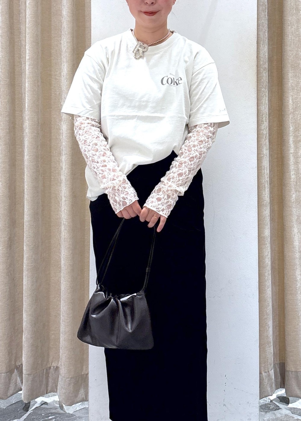 ブラック系のスカート、ホワイト系のその他トップス、ブラウン系のハンドバッグを着用したレディースの夏コーディネートの6枚目の写真