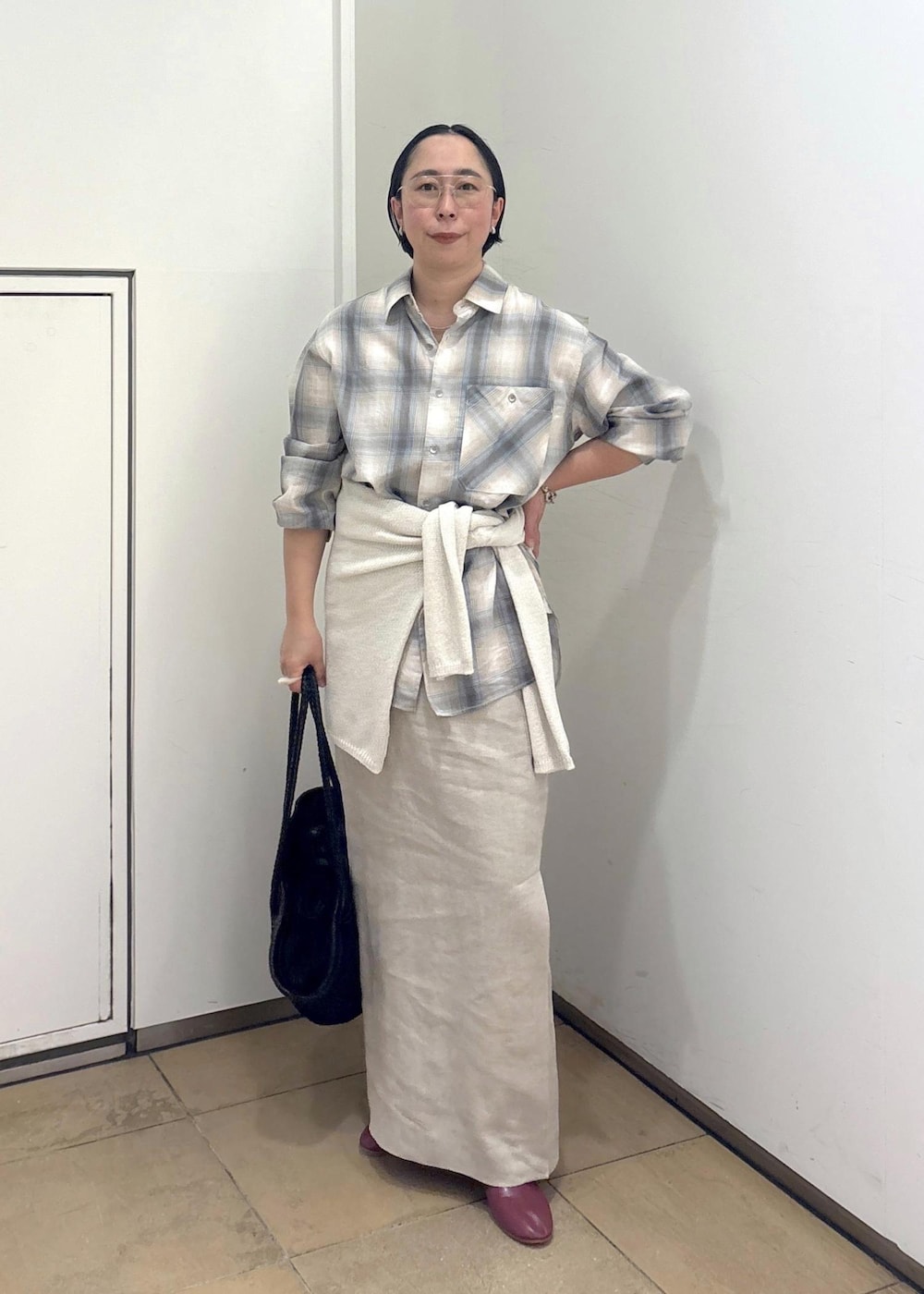 ブラック系のトートバッグ、ベージュ系のスカート、グリーン系のシャツ/ブラウスを着用したレディースの春コーディネートの2枚目の写真