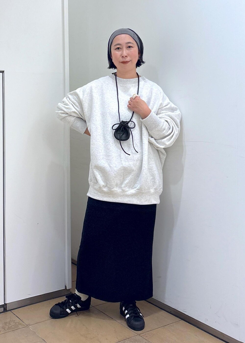 グレー系のスウェット、ブルー系のスカート、グレー系のヘアバンドを着用したレディースの冬コーディネートの5枚目の写真