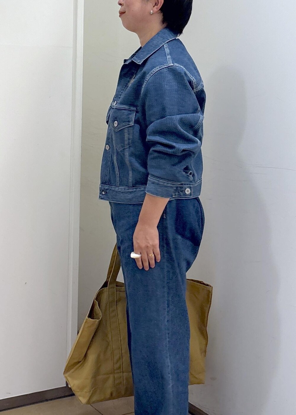 ブルー系のデニムジャケット、ブルー系のデニムパンツ、ブラック系のパンプスを着用したレディースの秋コーディネートの8枚目の写真