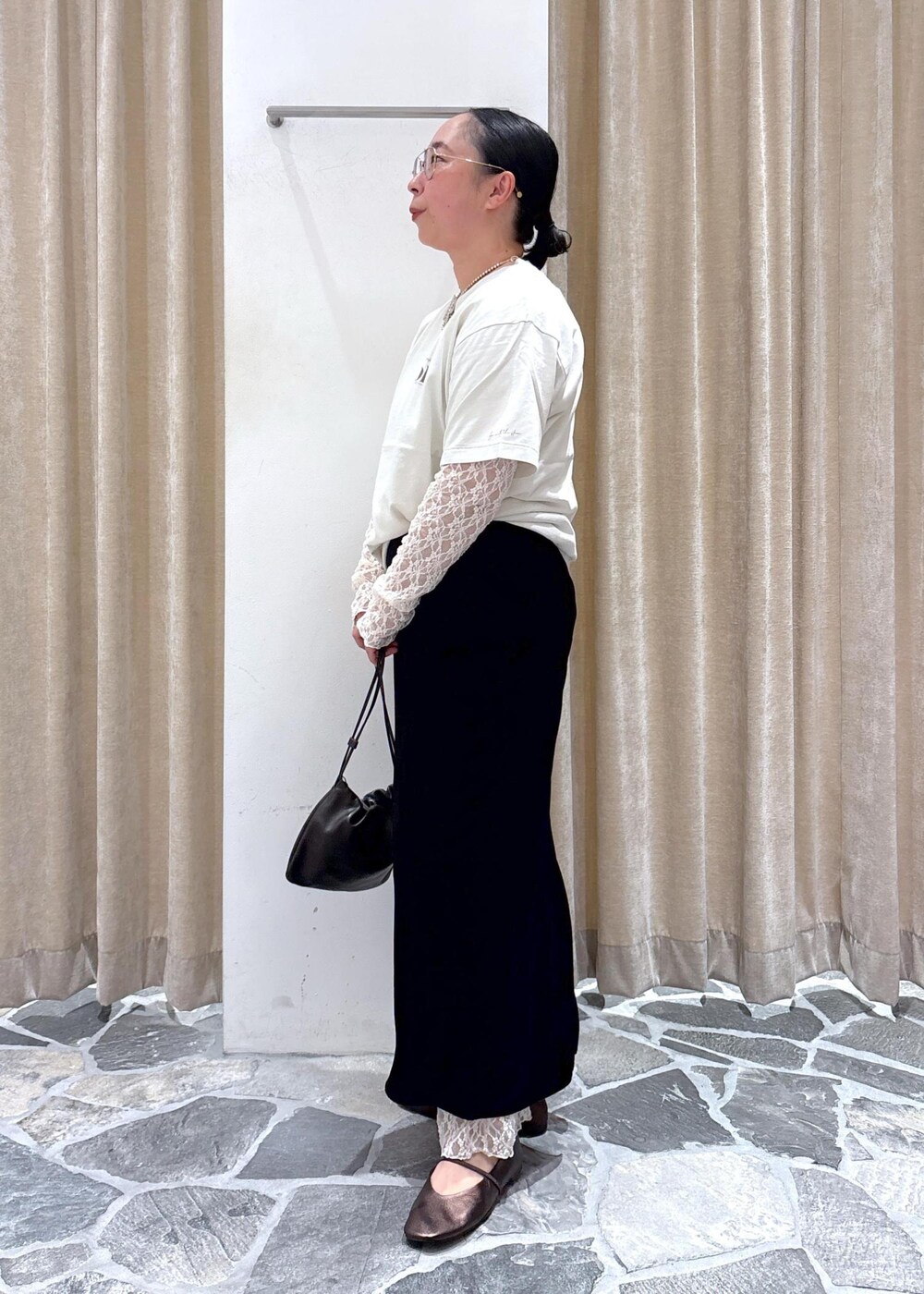 ブラック系のスカート、ホワイト系のその他トップス、ブラウン系のハンドバッグを着用したレディースの夏コーディネートの4枚目の写真