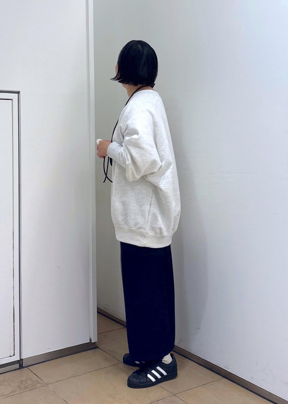 グレー系のスウェット、ブルー系のスカート、グレー系のヘアバンドを着用したレディースの冬コーディネートの7枚目の写真