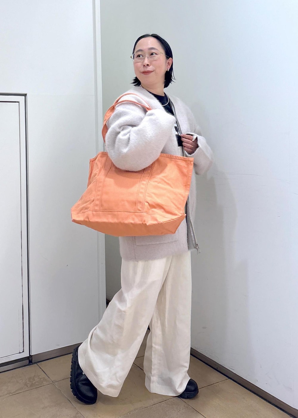 ブラック系のスウェット、グレー系のブルゾン、ホワイト系のサロペット/オーバーオールを着用したレディースの冬コーディネートの3枚目の写真