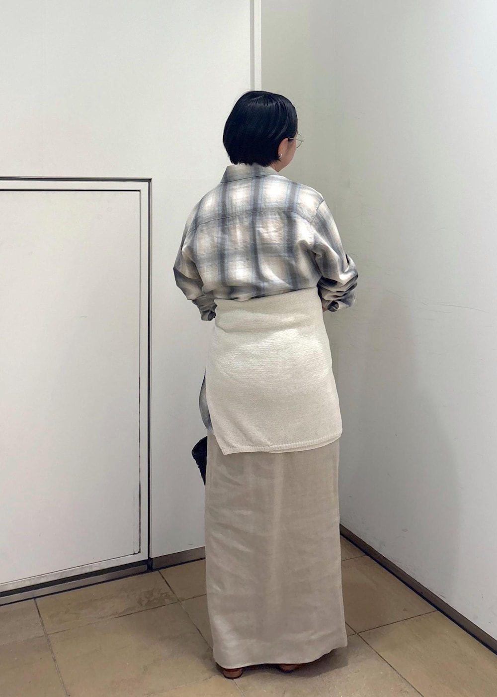 ブラック系のトートバッグ、ベージュ系のスカート、グリーン系のシャツ/ブラウスを着用したレディースの春コーディネートの4枚目の写真