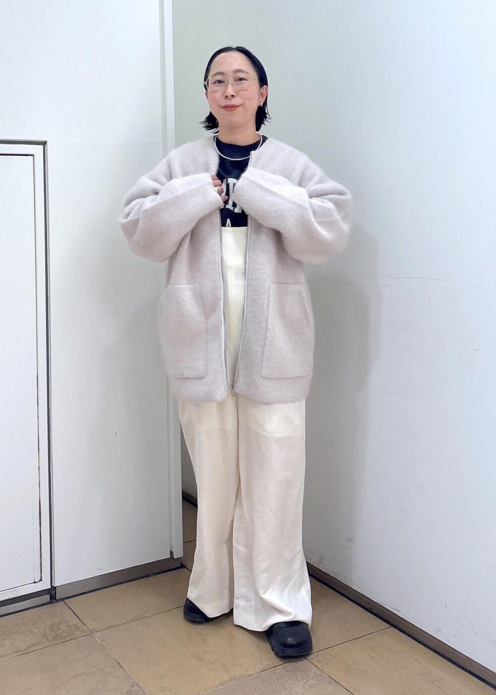 ブラック系のスウェット、グレー系のブルゾン、ホワイト系のサロペット/オーバーオールを着用したレディースの冬コーディネートの6枚目の写真