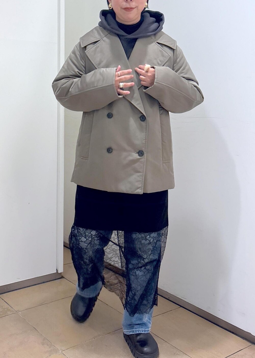 グレー系のパーカー、グリーン系のダウンジャケット/コート、ブラック系のボストンバッグを着用したレディースの冬コーディネートの7枚目の写真