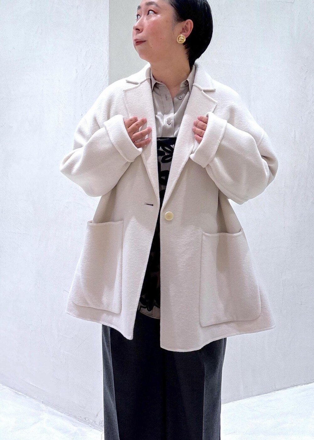 グレー系のスラックス、ブラック系のスカート、グレー系のシャツ/ブラウスを着用したレディースの秋コーディネートの8枚目の写真