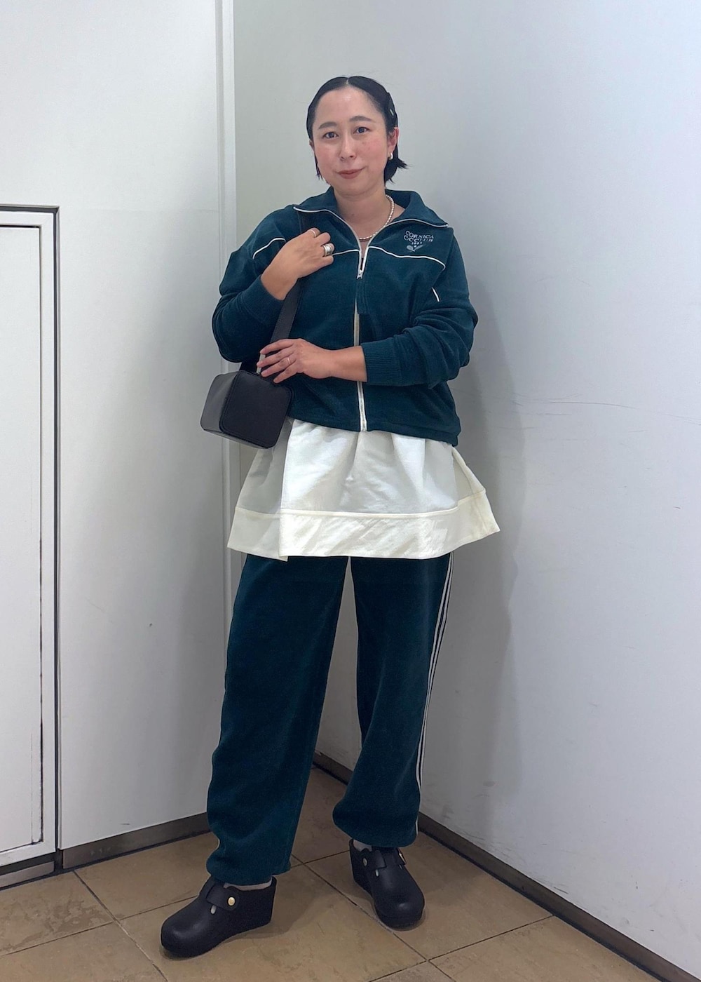 ブラック系のショルダーバッグ、ブラック系のタンクトップ、グリーン系のその他パンツを着用したレディースの冬コーディネートの3枚目の写真