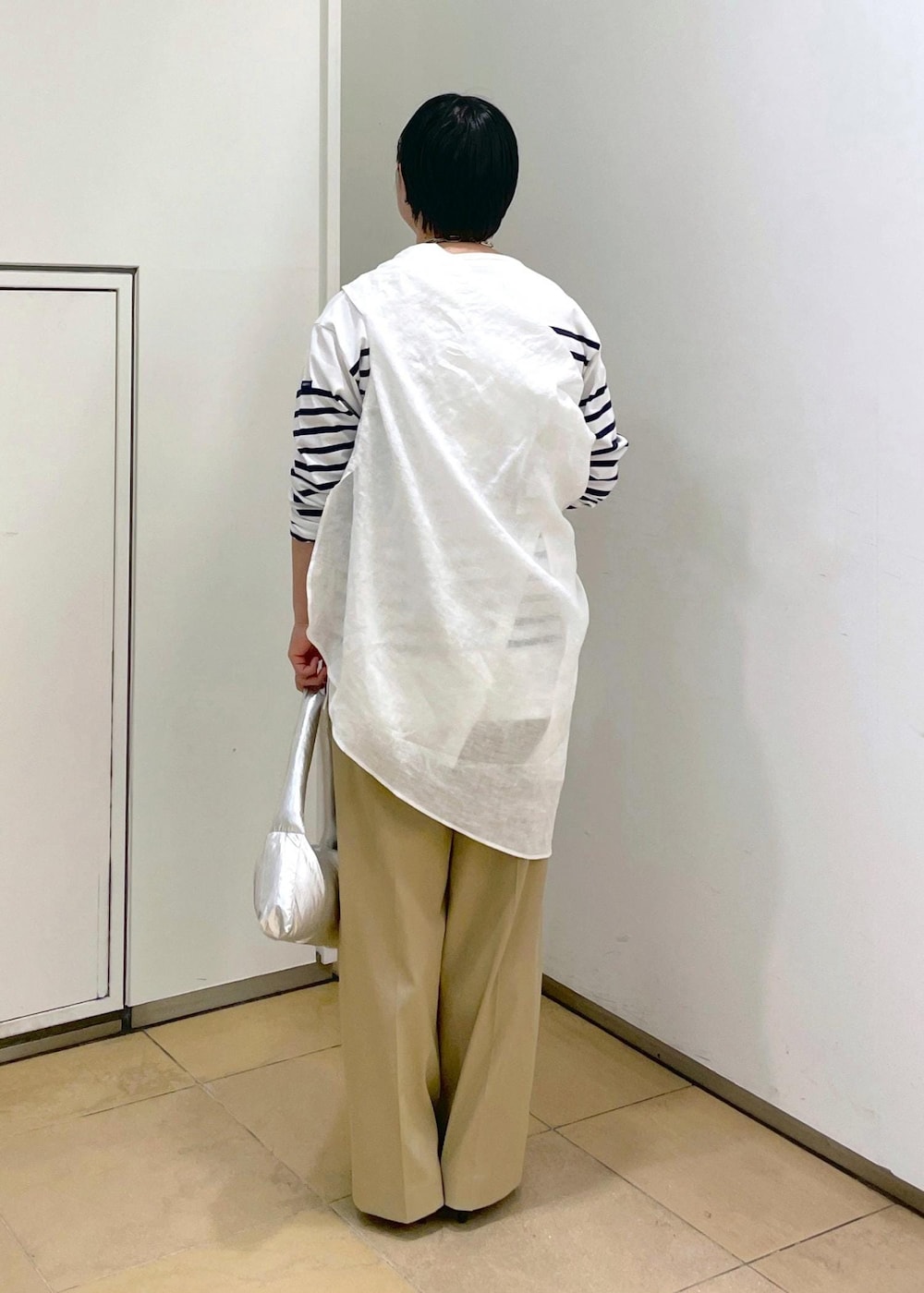 ブラック系のサンダル、シルバー系のハンドバッグ、ホワイト系のシャツ/ブラウスを着用したレディースの春コーディネートの5枚目の写真