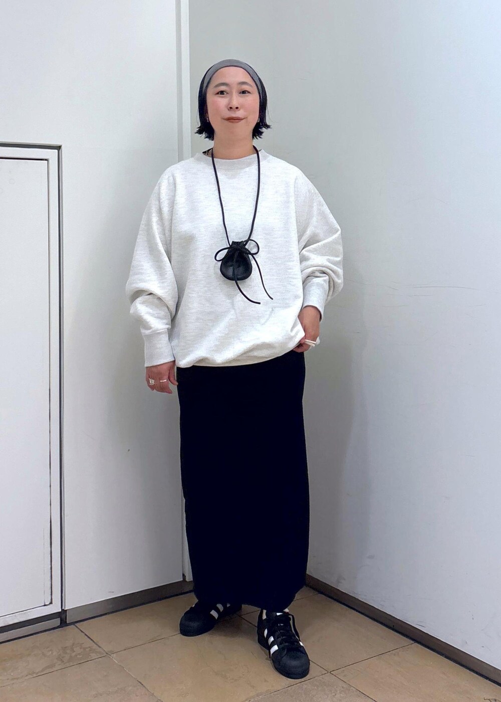 グレー系のスウェット、ブルー系のスカート、グレー系のヘアバンドを着用したレディースの冬コーディネートの9枚目の写真