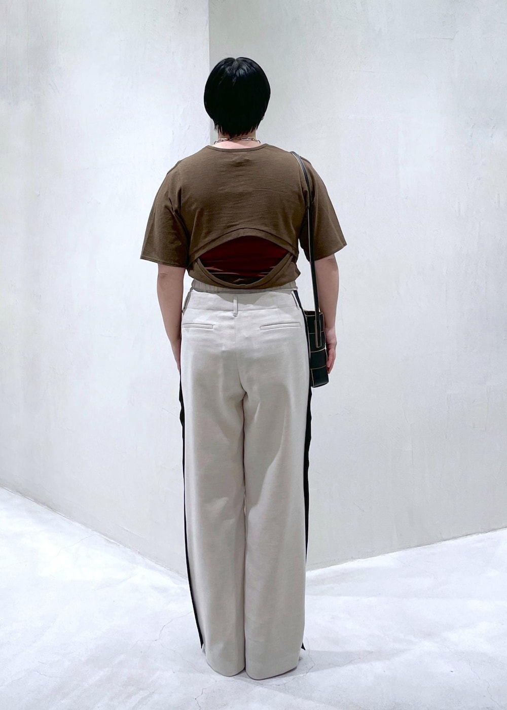 ブラック系のショルダーバッグ、ホワイト系のその他パンツ、ブラウン系のTシャツ/カットソーを着用したレディースの春コーディネートの4枚目の写真