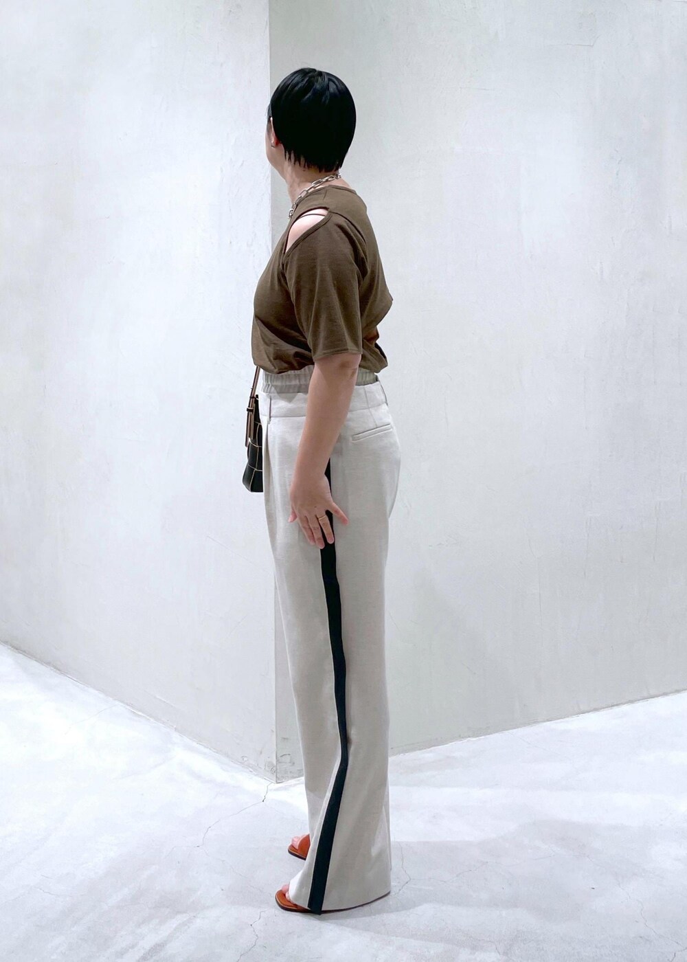 ブラック系のショルダーバッグ、ホワイト系のその他パンツ、ブラウン系のTシャツ/カットソーを着用したレディースの春コーディネートの3枚目の写真