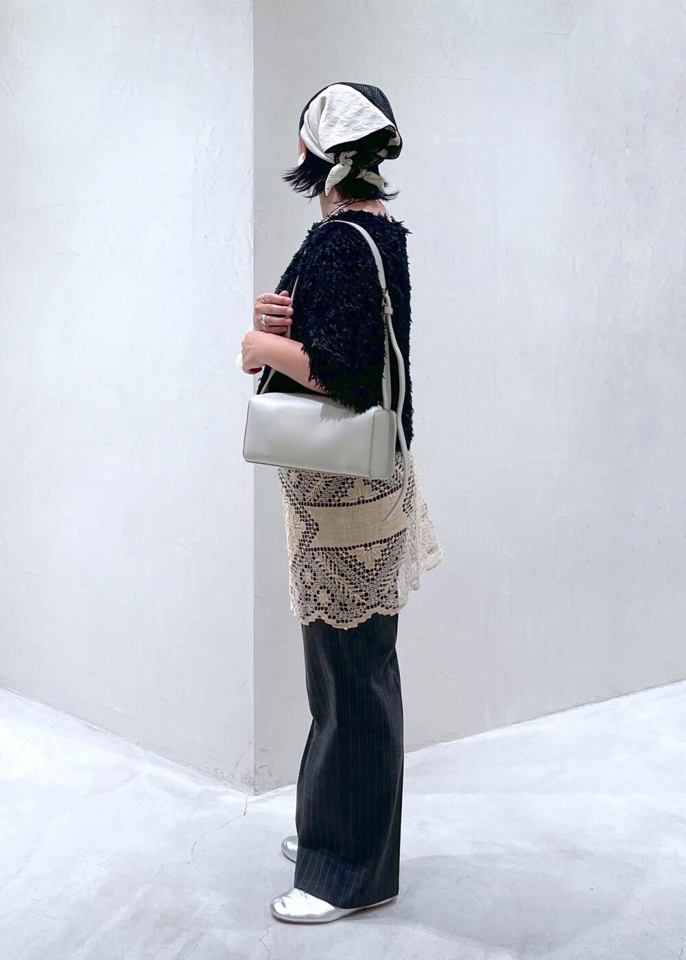 ブラック系のTシャツ/カットソー、グレー系のスラックス、グレー系のショルダーバッグを着用したレディースの夏コーディネートの4枚目の写真