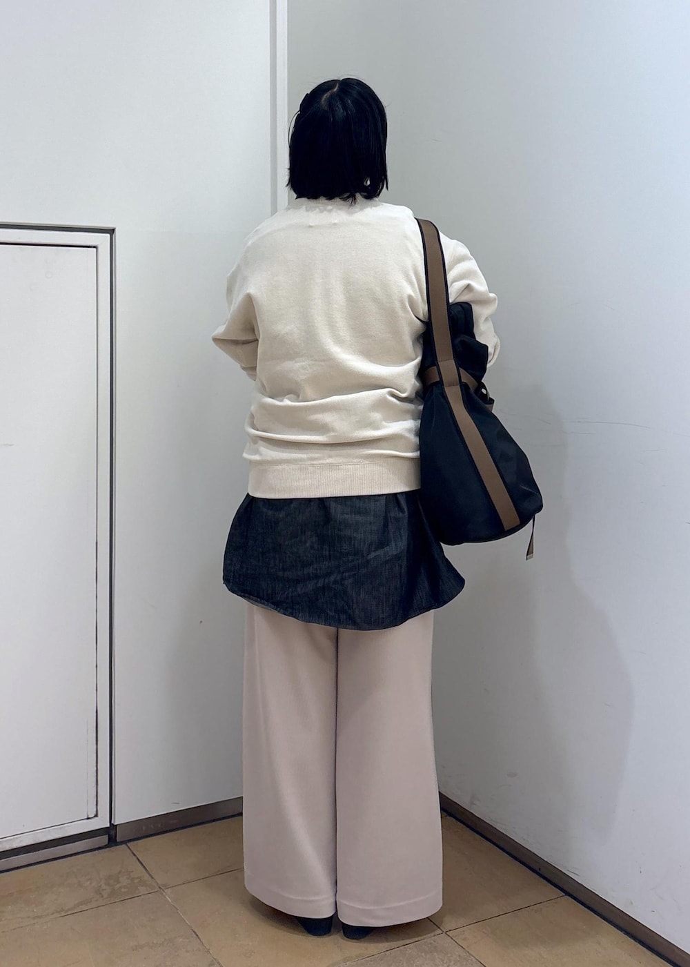 ブラック系のTシャツ/カットソー、ホワイト系のスウェット、ブラック系のトートバッグを着用したレディースの冬コーディネートの8枚目の写真