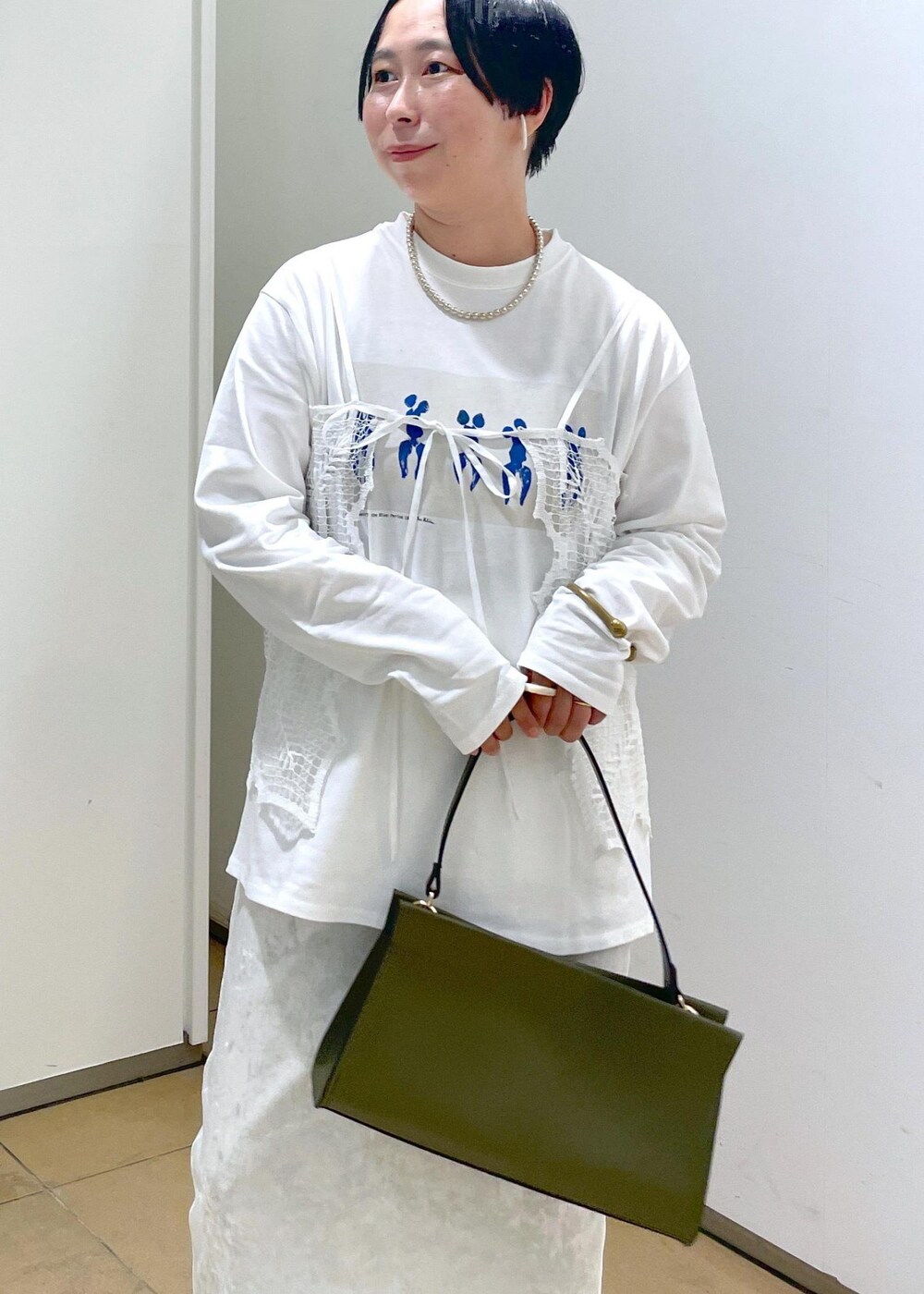 ホワイト系のスカート、ブラック系のデニムパンツを着用したレディースの夏コーディネートの8枚目の写真