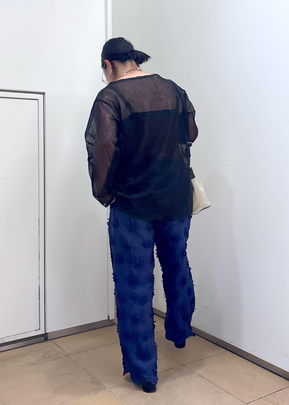 ブラック系のニット/セーター、ブルー系のその他パンツ、ホワイト系のショルダーバッグを着用したレディースの夏コーディネートの7枚目の写真