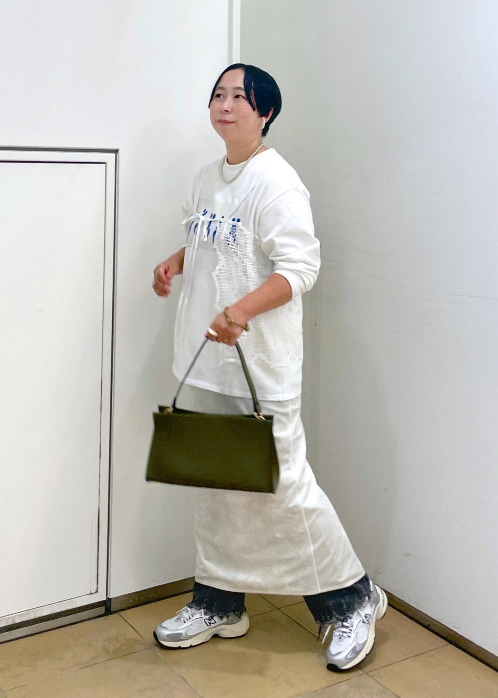 ホワイト系のスカート、ブラック系のデニムパンツを着用したレディースの夏コーディネートの6枚目の写真