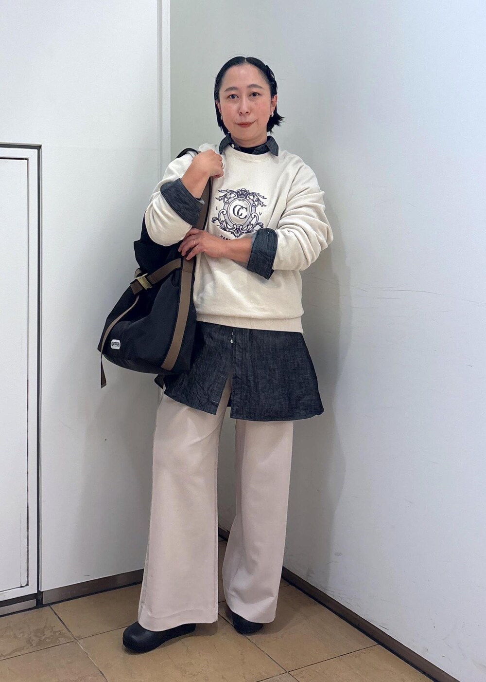 ブラック系のTシャツ/カットソー、ホワイト系のスウェット、ブラック系のトートバッグを着用したレディースの冬コーディネートの4枚目の写真