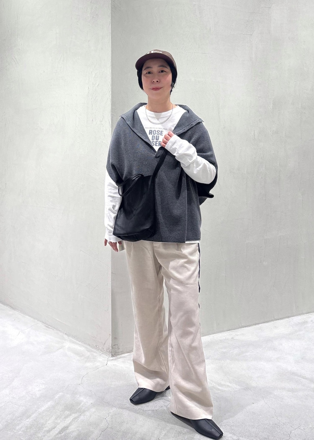 グレー系のニット/セーター、ブラック系のその他シューズ、ホワイト系のTシャツ/カットソーを着用したレディースの冬コーディネートの3枚目の写真