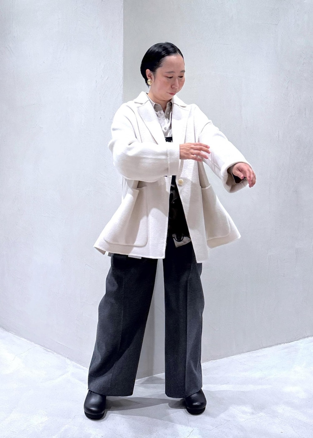 グレー系のスラックス、ブラック系のスカート、グレー系のシャツ/ブラウスを着用したレディースの秋コーディネートの4枚目の写真