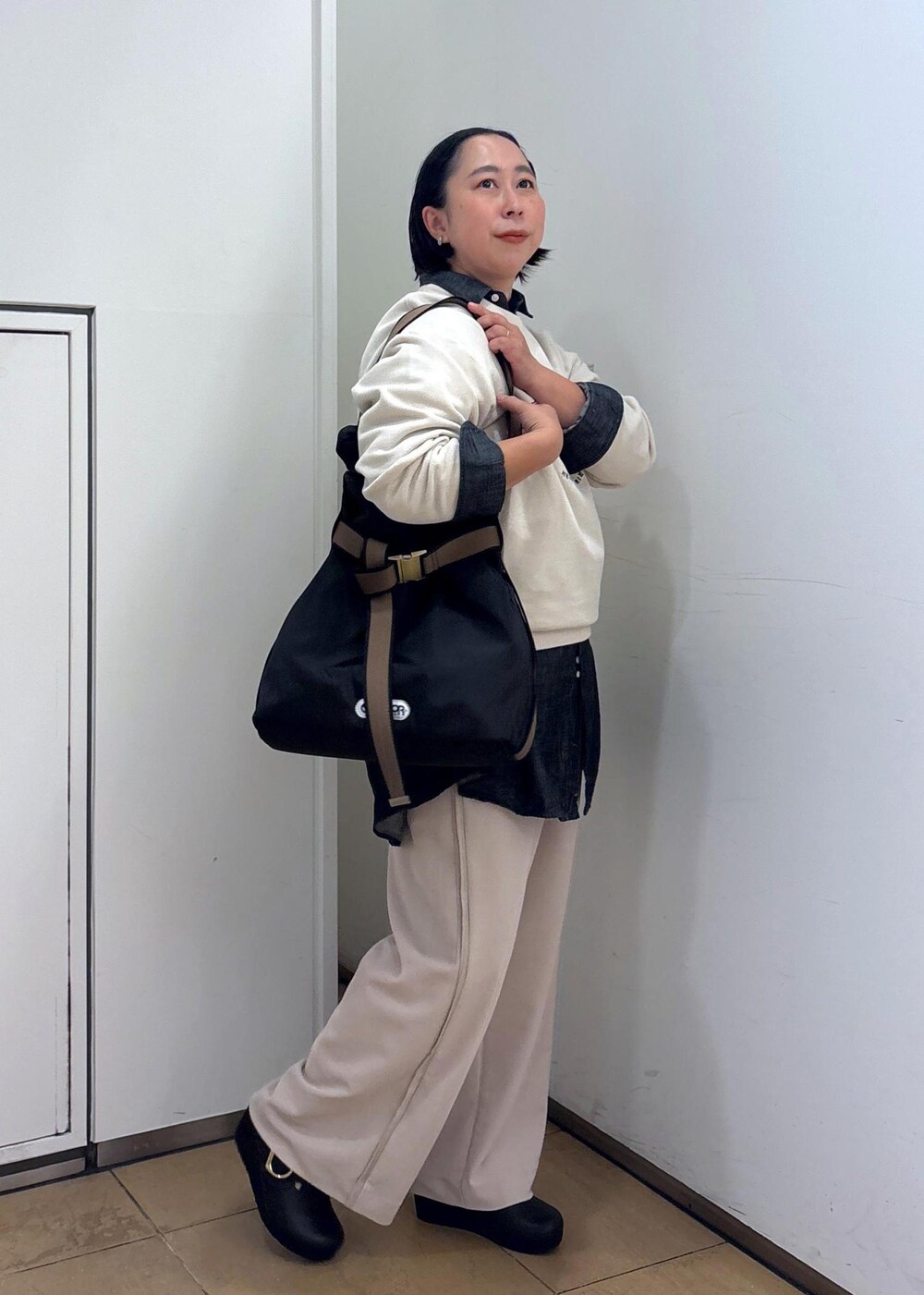 ブラック系のTシャツ/カットソー、ホワイト系のスウェット、ブラック系のトートバッグを着用したレディースの冬コーディネートの6枚目の写真