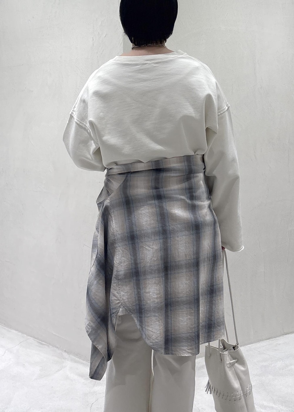 ブラック系のスニーカー、ホワイト系のショルダーバッグ、ブルー系のシャツ/ブラウスを着用したレディースの春コーディネートの7枚目の写真