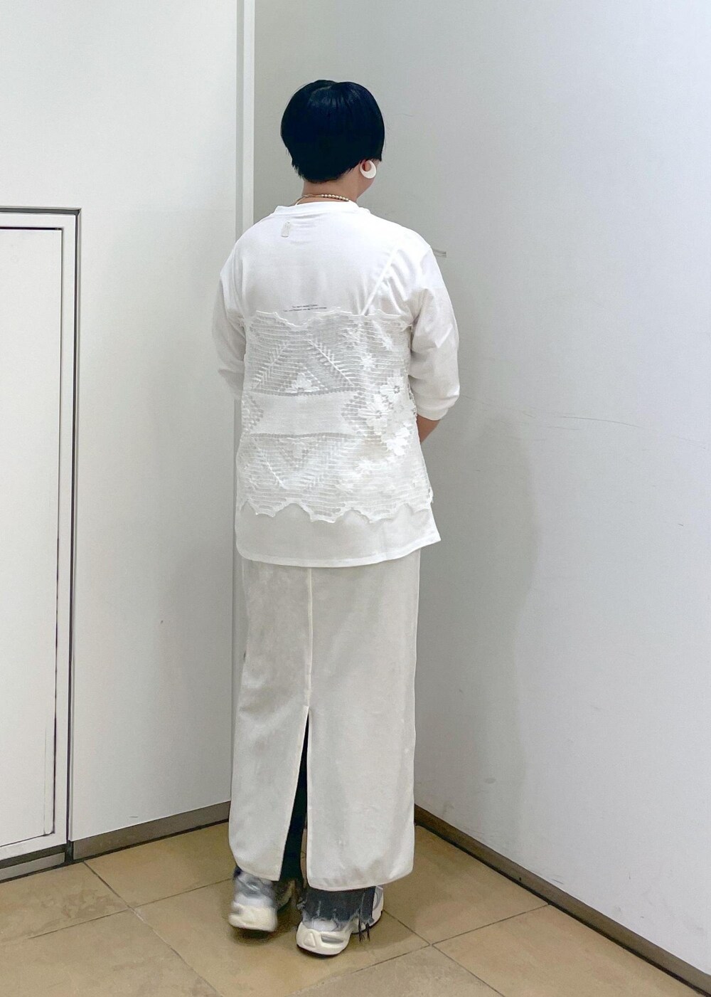 ホワイト系のスカート、ブラック系のデニムパンツを着用したレディースの夏コーディネートの7枚目の写真